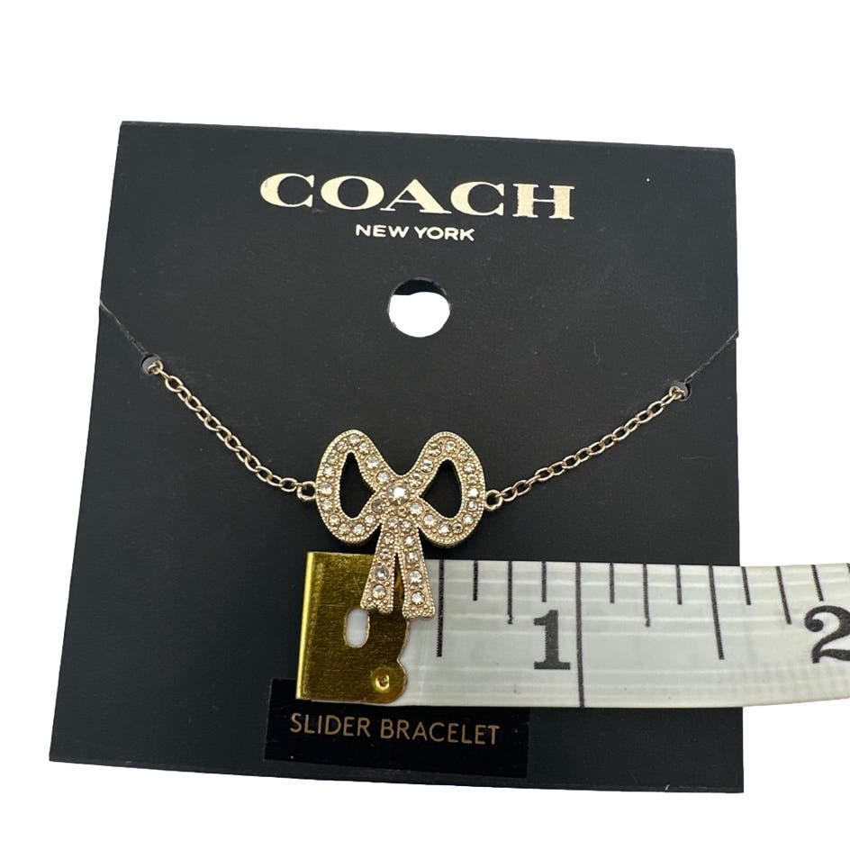 NWT Coach Pave Crystal Gold Tone Ribbon Charm Slider Bracelet